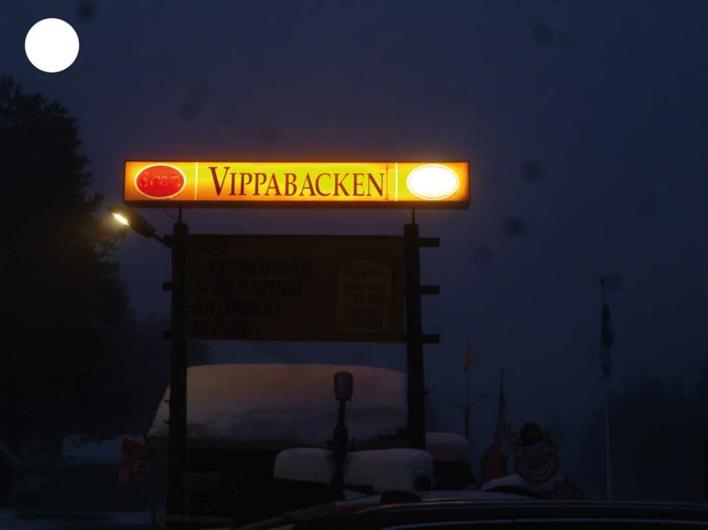 Devanture de restaurant éclairée dans la nuit en Laponie, créant une ambiance chaleureuse au cœur du paysage nordique.