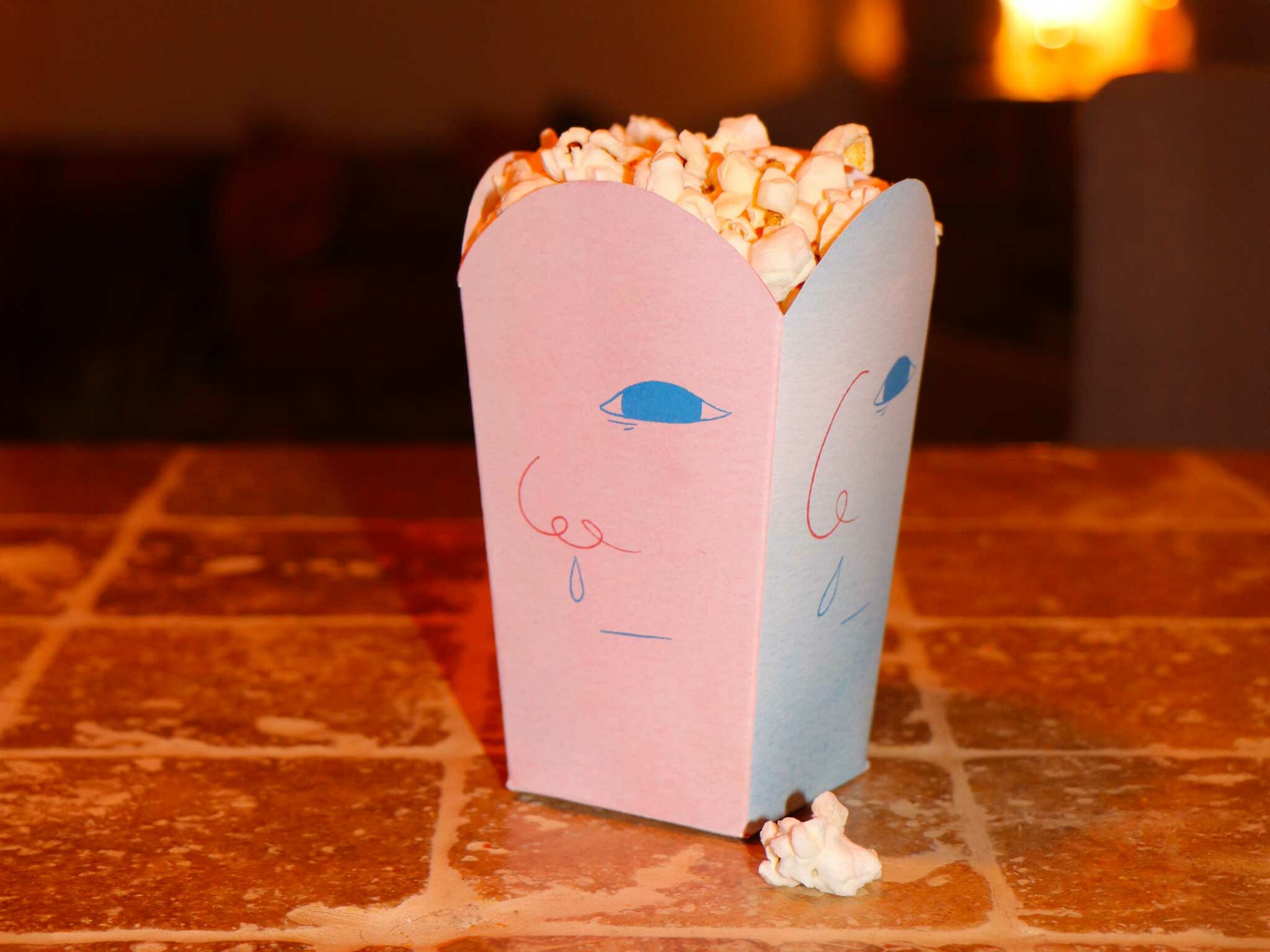 Photographie des paquets de pop-corn rose pour le cinéma Morveux avec le design du visage d’enfant morve au nez et ambiance colorée.