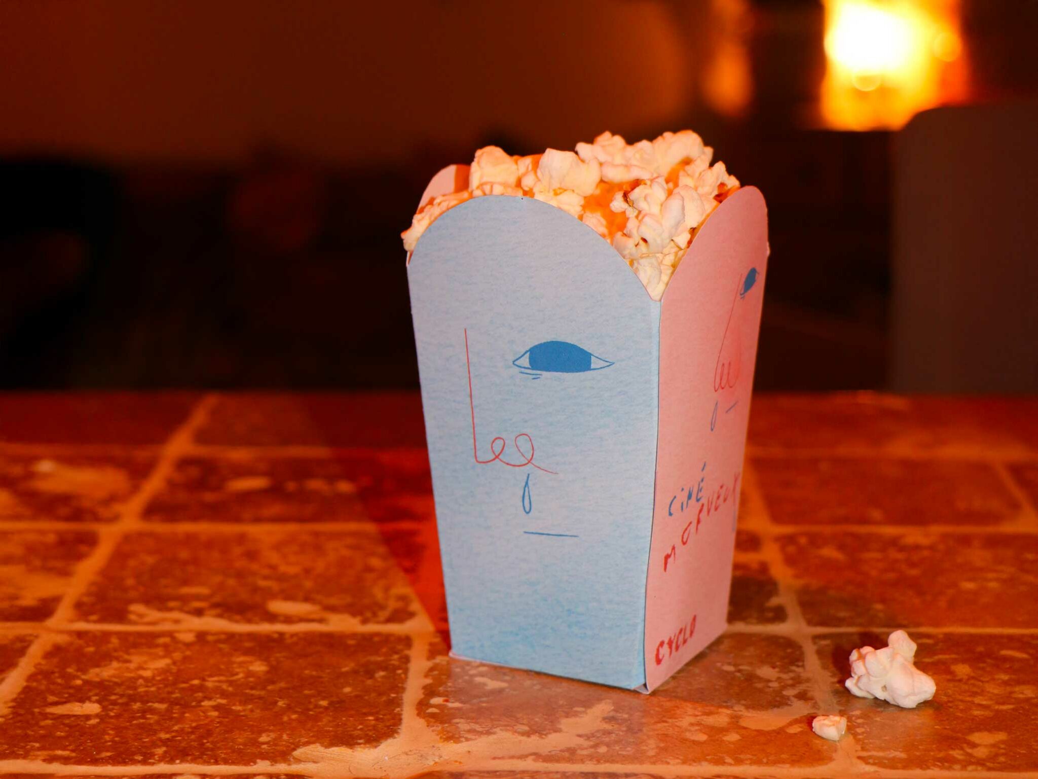 Photographie des paquets de pop-corn rose pour le cinéma Morveux avec le design du visage d’enfant morve au nez et ambiance colorée.