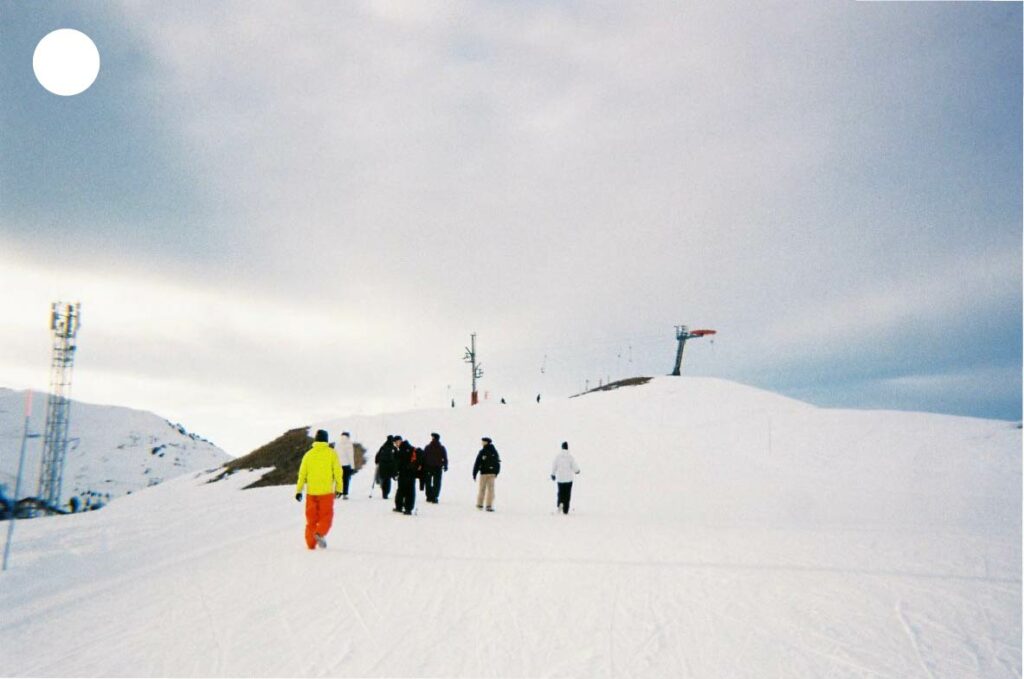 Silhouettes de personnes marchant dans la neige fraîche, laissant des traces éphémères dans un paysage hivernal immaculé.